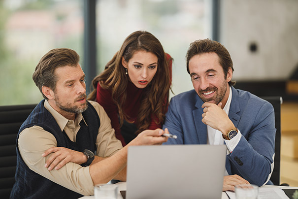Skupina ľudí sa pozerá do notebooku